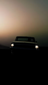 Vintage Car Silhouette Headlights Glowing at Twilight