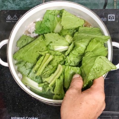 Cho rau vào. Sau đó nêm nếm ít gia vị. Chờ nước sôi thêm lần nữa là đã có thể tắt bếp.