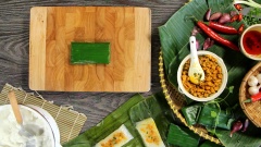 Lật mặt lá chuối có màu nhạt hơn để gói bánh nậm. Cho khoảng 1 muỗng canh bột bánh nậm vào lá chuối, dàn đều, cho nhân vào giữa và gói lại thành miếng chữ nhật. Sau đó cho bánh nậm vào nồi hấp khoảng 15 phút.