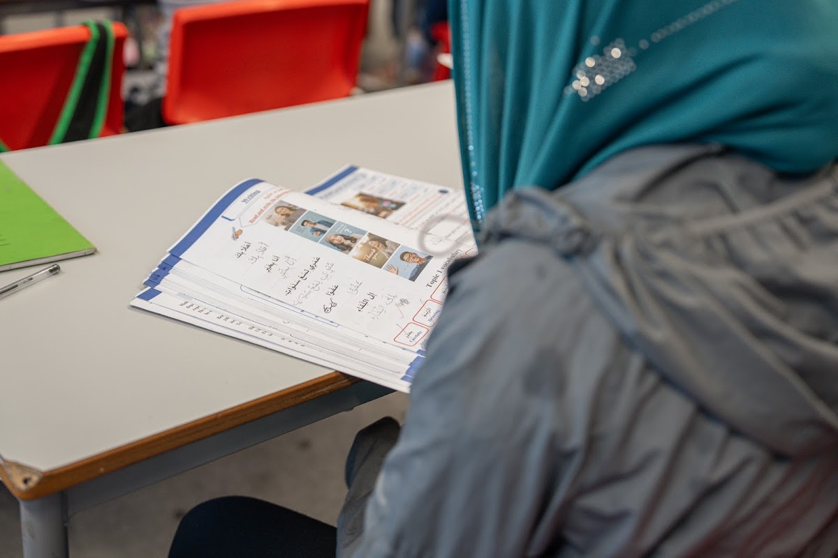 Student reading Arabic worksheets