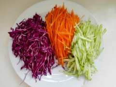 Cải bắp, cà rốt, dưa chuột thái sợi. Sau khi chiên trứng bạn thêm chút dầu ăn vào chảo rồi cho xúc xích vào chiên chín .