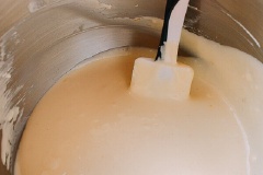 Sử dụng máy đánh trứng, đánh nhuyễn kem phô mai. Thêm đường rồi trộn cho mịn. Thêm sữa, rồi lần lượt cho trứng vào, đánh đến khi hòa quyện. Cuối cùng, trộn thêm kem chua, tinh chất vani, vỏ chanh và bột mì.