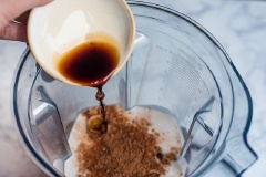 Chuẩn bị các nguyện liệu, cho lần lượt nước cốt dừa, trái chà là, bột cacao đen không đường vào máy xay sinh tố.
