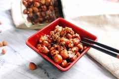 Cho mè rang lên trên đậu phộng. Để đậu phộng nguội thì có thể ăn ngay hoặc cho vào lọ, đậy kín.