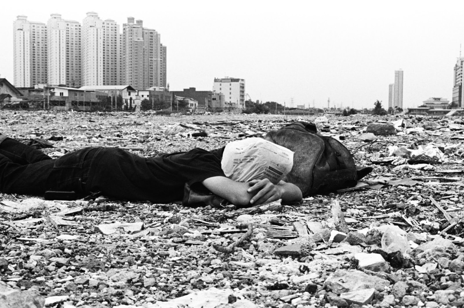 Man lying in the rubble. Climate change emotional impact, ecological catastrophes emotional impact, ecological grief Indonesia, climate grief Indonesia, reef grief Indonesia. CarbonEthics Indonesia