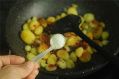 Đảo đều đến khi các mặt khoai đều vàng cam thì nêm vào 1 muỗng canh sốt ớt đậu cay, 1/2 muỗng cà phê muối, đảo đều và nhẹ tay cho khoai ngấm gia vị, tắt bếp.