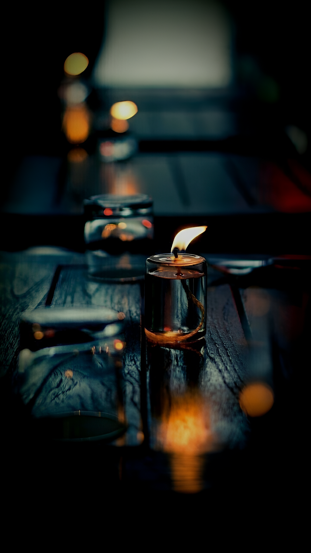 Single Candle Glowing on Dark Wooden Table - Free 4K mobile Wallpaper