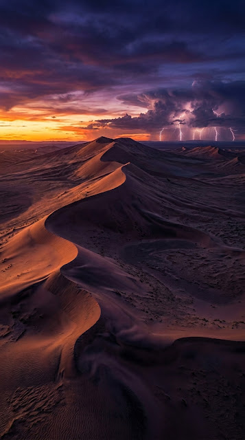 Surreal Desert Landscape at Twilight with Distant Lightning Storm - Free mobile Wallpaper