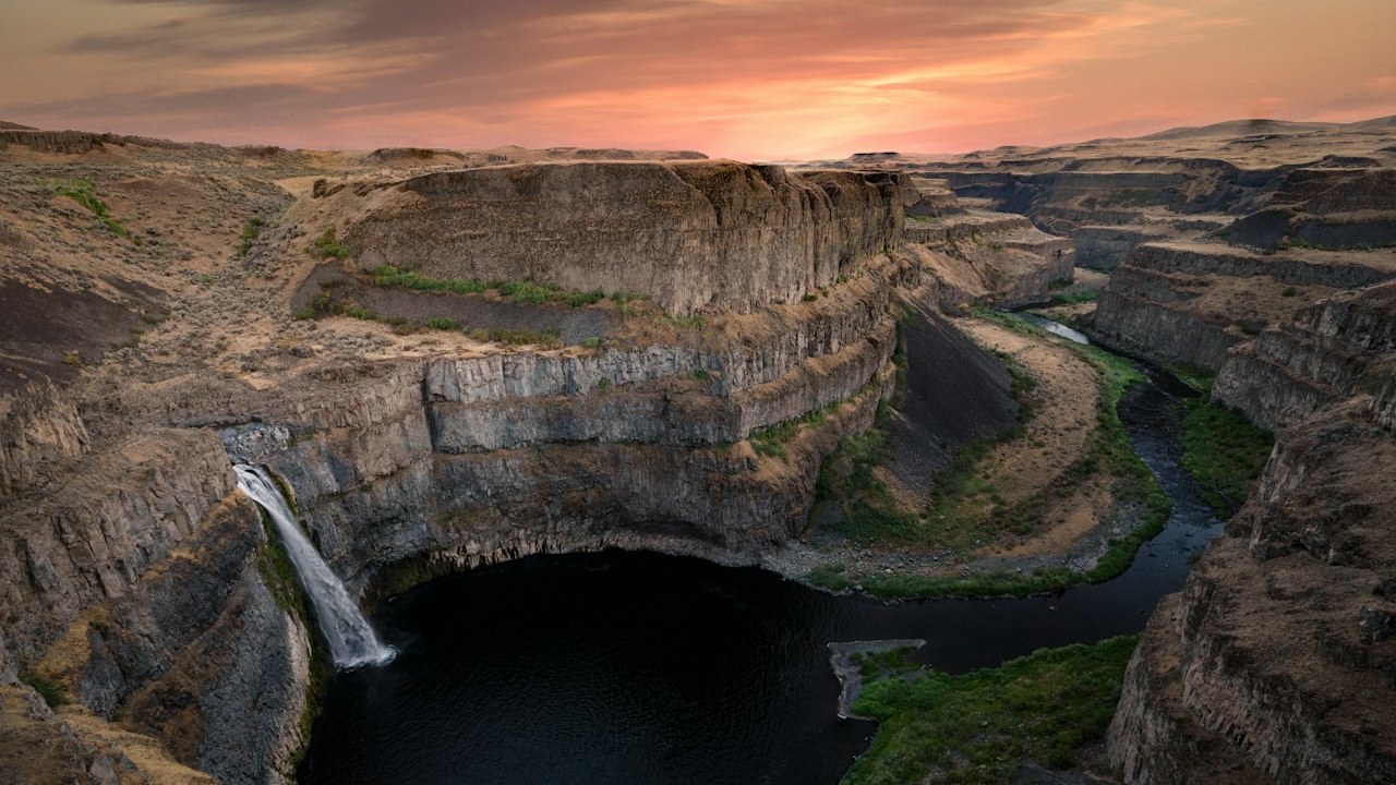Palouse Falls plunging 198 feet into a circular columnar basalt canyon basin in eastern Washington at sunset