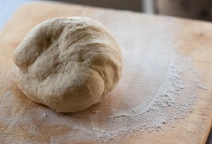Trộn đều 100g bột mì, 1 muỗng cà phê bột nở, 20g đường trắng, 2/3 muỗng cà phê muối và 30g bơ. Cho từ từ sữa tươi vào và nhồi thành khối sáng mịn.