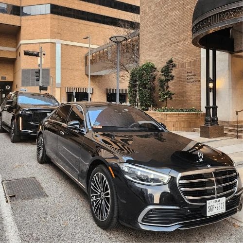 Black Mercedes-Benz S-Class sedan parked outside a building entrance