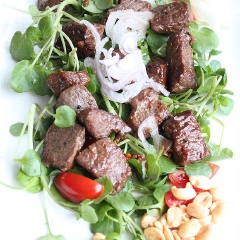 Cuối cùng, trước khi dùng cho thịt bò ra đĩa, trang trí với ít xà lách xoong, cà chua bi và đậu phộng rang xung quanh, sau đó gắp ít củ hành lên.