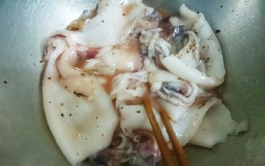 Đổ nước kim chi vào tô mực đã ướp, để thêm 30 phút cho ngấm.