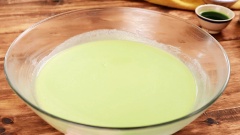 Khuấy đều 150g trứng gà, 20g nước cốt lá dứa, 200g đường cát, 200g bột năng, 4g baking soda, 4g baking powder và hỗn hợp bơ sữa. Sau đó cho cơm dừa vào khuấy đều