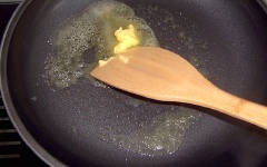 Đun chảy 1 muỗng canh bơ rồi cho chén trứng vào, dàn đều.