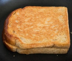 Làm nóng 2 muỗng canh dầu ăn trong chảo, cho bánh mì sandwich vào, chiên vàng giòn 2 mặt.