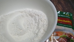Đầu tiên chúng ta sẽ làm bột chiên giòn nhúng nấm. Cho bột chiên giòn vào tô, cho từ từ nước lạnh vào tô bột rồi khuấy đều đến khi hỗn hợp đặc sệt, nặng tay. Nếu pha bột quá loãng sẽ làm nấm khi chiên không bám bột, không giòn nhé các bạn.