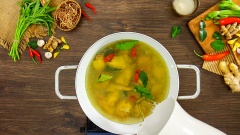 Bắc nồi lên bếp, cho vào 2 muỗng canh dầu ăn rồi làm nóng, sau đó cho phần thịt gà chặt khúc vào xào săn. Thêm 10gr ớt sừng, 10gr lá chúc (lá chanh Thái) tước bỏ cuống, xào thêm 2 phút nữa cho lá chúc dậy mùi. Sau đó châm vào nòi 1.5 lít nước lọc, khuấy đều rồi nấu 20 phút cho thịt gà mềm.