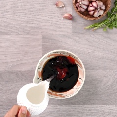 Chuẩn bị cái tô nhỏ, cho vào 2 muỗng canh nước tương, 1 muỗng canh hắc xì dầu, 1 muỗng canh tương ớt, 1 muỗng canh dầu mè và 150ml nước dừa tươi, dùng muỗng khuấy đều cho tan.