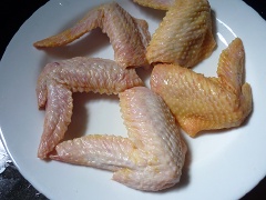 Cánh gà rửa sạch, chặt làm đôi, cho ra đĩa để ráo nước.