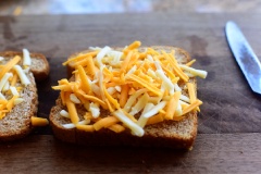 Đặt một miếng bánh mì sandwich lên thớt, phết lớp bơ phỏng, rắc một lớp mỏng phô mai sợi (loại tùy sở thích nhé). Miếng sandwich còn lại cũng phết lớp bơ, rắc thật nhiều phô mai sợi. Lấy miếng sandwich ít phô mai đậy phần không có phô mai lên trên miếng bánh mì còn lại.