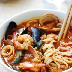 Sau đó, chế 1 lít nước dùng gà vào và nấu sôi đến khi rau chín thì cho lần lượt cá, tôm, nghêu, vẹm xanh và mực vào nấu. Đến khi nước sôi bùng trở lại, nghêu cùng vẹm mở miệng thì nêm nếm gia vị vừa ăn thì tắt bếp. Nấu nồi nước sôi, thả mì vào luộc chín mềm 2 - 3 phút thì vớt ra, xả qua nước lạnh, để ráo. Khi ăn cho mì ra tô, hâm nóng nước dùng và chế vào mì rồi thưởng thức.