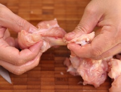 Dùng dao lọc phần thịt ở đầu nhỏ hơn của cánh gà rồi dồn thịt xuống bên dưới và lật thịt làm cho miếng cánh gà giống như một chiếc kẹo que.
