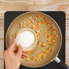 Phi thơm 2 muỗng canh tỏi băm, 1 muỗng canh ớt băm, rồi cho 2 muỗng canh đường vào thắng cho hơi ngã màu caramel, cho tiếp 2 muỗng canh nước mắm, 2 muỗng canh tương ớt, 2 muỗng canh nước cốt tắc, nấu sôi cho hỗn hợp keo lại, rồi trút phần mực chiên vào và đảo đều cho mực áo đều sốt.