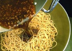 Cho mì Ý đã luộc vào thau sạch, thêm sốt vừa nấu xong vào cùng, dùng đũa trộn đều để mì thấm sốt.