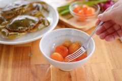 Lấy trứng lòng đỏ trứng muối và rửa sạch, dùng một nồi lớn hấp cách thuỷ khoảng 15 phút cho trứng vừa chín thì nhắc xuống để nguội. Tiếp tục nghiền nhuyễn các lòng đỏ trứng muối đã hấp để chuẩn bị làm sốt. Cho 20ml dầu ăn và 1 muỗng cà phê tỏi băm vào, đến khi tỏi dậy mùi thơm thì cho trứng muối vào, cho thêm 2 muỗng canh đường, 1 muỗng canh nước mắm cho hương vị đậm đà. Đảo đều đến khi hỗn hợp sền sệt lại thì tắt bếp.