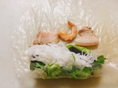 Thịt ba chỉ sau khi luộc xong thì thái mỏng. Bánh tráng thấm hơi ướt, xếp từng lớp lần lượt rau, bún, thịt, tôm và cuốn chặt đều tay. Gần phía cuối thấm thêm một ít nước lên mép để cuốn được kín.