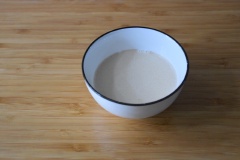 Cho 100ml sữa tươi ra chén, đặt vào chậu lớn, đổ nước ấm vào xung quanh chén sữa tươi để làm ấm sữa tươi nhé! Khi sữa tươi đã được làm ấm thì thêm 2g men nở vào chén sữa khuấy cho quyện đều.