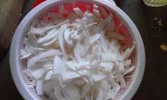 Để mứt dừa gấc ngon, bạn nên chọn cùi dừa gọt bỏ vỏ nâu, rửa sạch, cắt thành những lát mỏng, ngâm trong nước cho ra bớt dầu rồi vớt ra đê ráo. Gấc tách lấy hạt, bóp cùng rượu trắng, lọc qua rây, bỏ lợn cợn. Cho 500g đường và gấc vào tô dừa trộn đều, ướp khoảng 2-8 tiếng cho đường thấm và gấc lên màu đẹp.