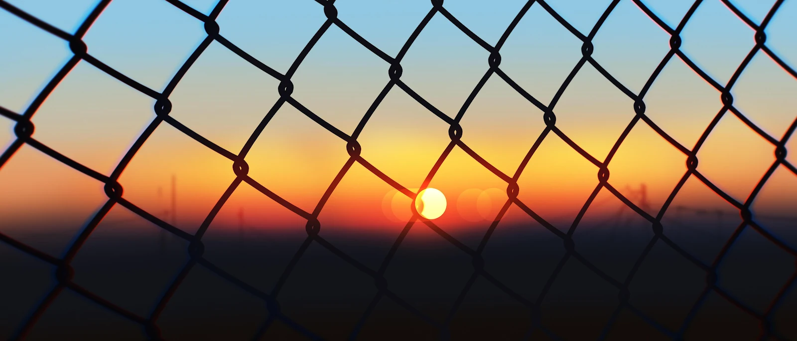 Sunset Through Chain Link Fence 4K Desktop Wallpaper