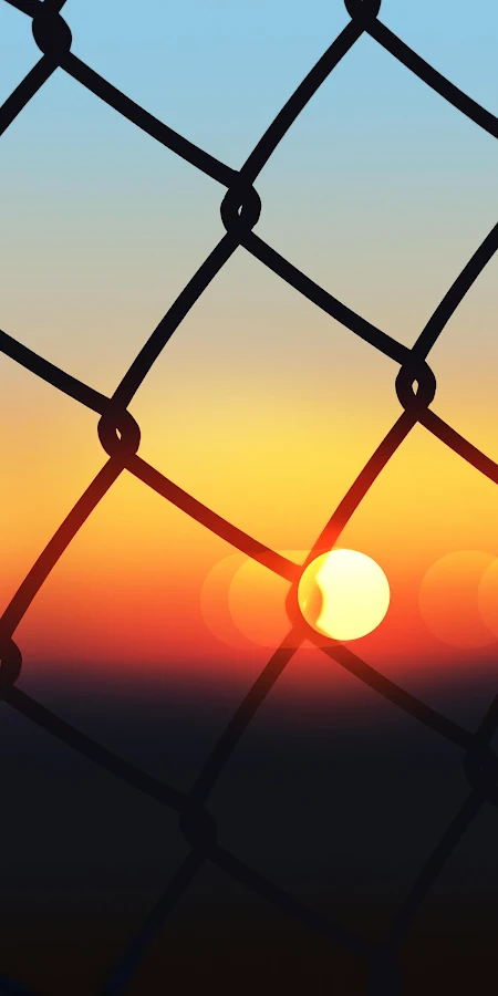 Sunset Through Chain Link Fence 4K Phone Wallpaper