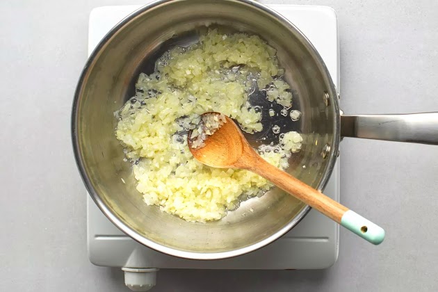 cebollas y ajo cocinándose en una cacerola