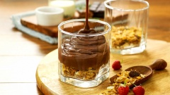 Để món pudding thêm bổ dưỡng bạn cho 15gr ngũ cốc vào ly, đổ pudding đã nguội lên, giữ pudding trong tủ mát 1-2 tiếng. Trang trí thêm kem tươi và quả việt quất lên trên pudding cho đẹp mắt.