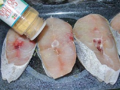 Làm nóng lò nướng đến 190 độ C (khoảng 375 độ F). Đặt nhữn miếng cá croaker vào khay nướng. Rắc muối và tiêu lên trên miếng thịt. Thêm bột tỏi, lá oregano xay và bột cà ri. Thoa đều rồi bặt một vài miếng bơ lên trên mỗi miếng cá. Nướng trong lò khoảng 30 phút hoặc cho đến khi cá chín vàng là được.
