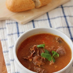 Múc thịt bò sốt vang ra chén, rắc ngò rí. Ăn cùng bánh mì.