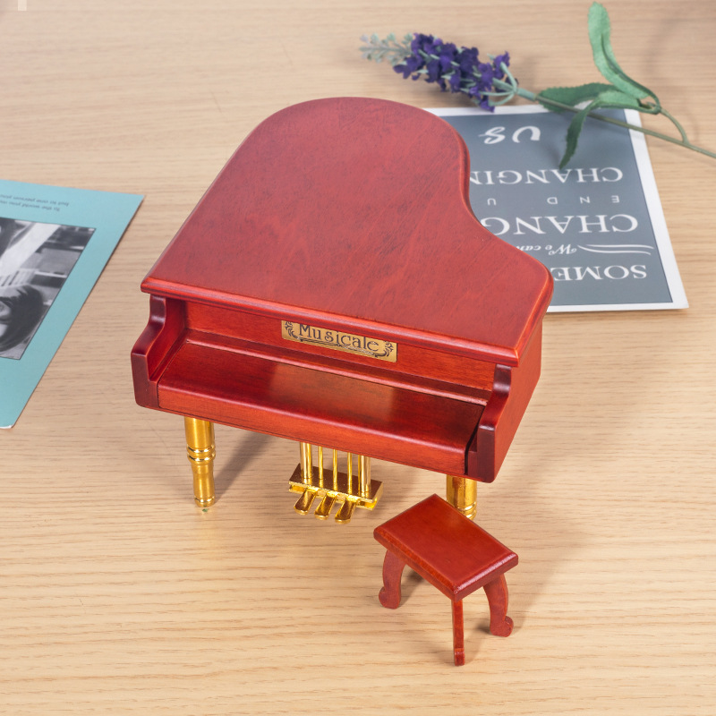 Wooden music box in the shape of a piano with metal feet