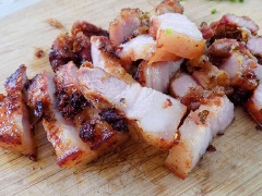Thịt ba chỉ lên men chiên giòn cắt miếng cho ra dĩa có xà lách, dưa leo.