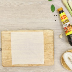 Gấp đôi miếng bánh tráng đông lạnh Singapore rồi cuốn hình phễu, đặt nhân vào trong và gấp mép thành hình tam giác.