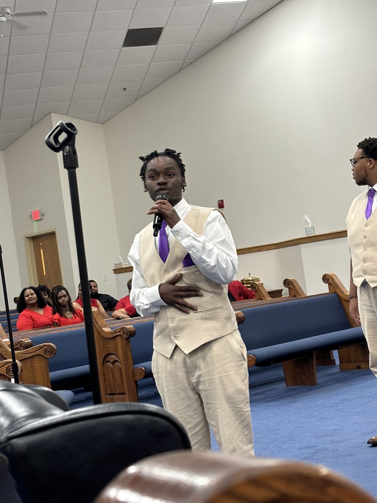 Young male vocalist in white suit with purple tie singing at Sharpe Road Homecoming Concert 2026