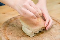 Thịt ba chỉ bạn thoa một lớp muối lên thịt, chà nhẹ nhàng và rửa lại bằng nước sạch để thịt không bị hôi. Sau đó cho thịt vào nồi, chế lượng nước vừa phải vào ngập thịt, thêm 15ml rượu, gừng, 5g hạt tiêu, hoa hồi vào. Đặt nồi lên bếp nấu đến khi nước sôi thì tắt bếp. Gắp thịt ra rổ cho ráo nước. Bạn dùng tăm nhọn hoặc que xiên đâm nhiều lỗ trên da heo.