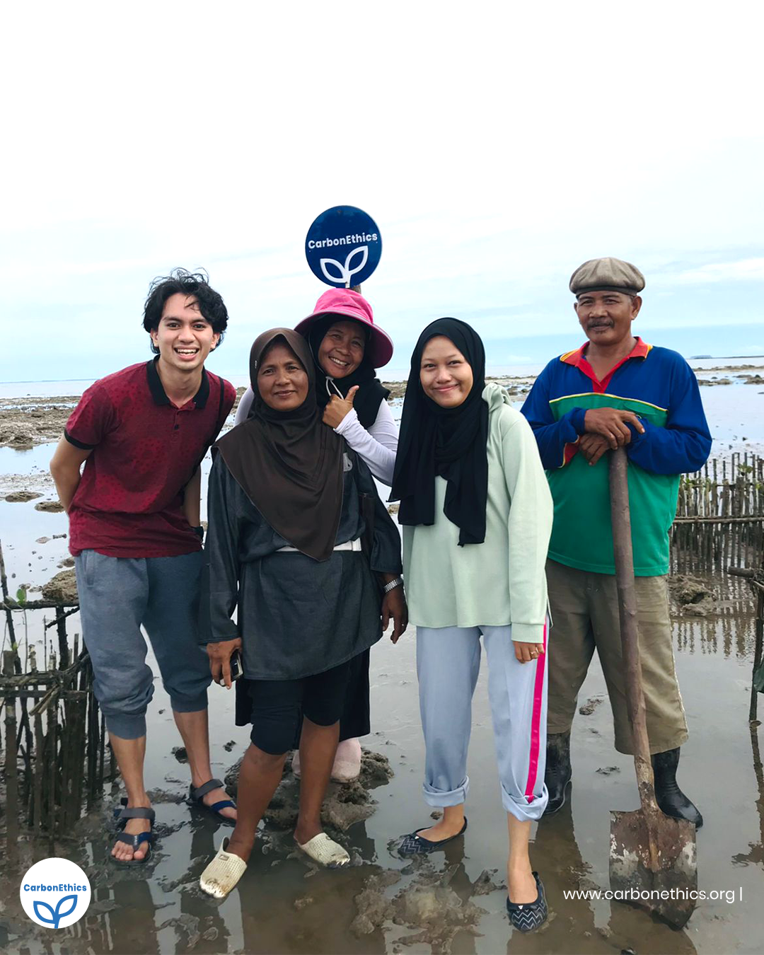 Carbonethics team and Petani Pesisir Dompak Laut farmers with CarbonEthics logo on a mangrove plantation site CarbonEthics Indonesia
