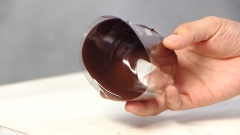 Chuẩn bị các ly nhựa. Dùng kéo cắt 1 bên thân ly và đáy ly. Dùng băng keo dính lại những phần vừa cắt. Dùng muỗng múc từng ít sô cô la đun chảy vào ly, dùng tay xoay ly để sô cô la bám kín đều vào ly. Để ly vào ngăn đông ít nhất 20 phút.