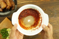 Khuấy tan nước mắm với đường trong một chén nhỏ, thêm vào ớt bột, ớt trái, dầu olive, húng lũi băm, những miếng chanh và vắt vào 1 lát chanh rồi trộn đều.