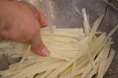 Khoai tây gọt vỏ rửa sạch, cắt lát mỏng rồi cắt sợi chỉ theo chiều dọc củ. Sau đó sả dưới vòi nước cho sạch.