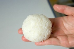 Dùng tay nắm chặt cơm thành hình tròn, cho ra đĩa.