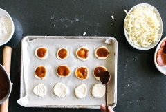 Xúc xích cắt mỏng tùy ý. Phô mai bào nhuyễn. Phết một lớp sốt cà chua loại làm bánh Pizza lên từng chiếc bột bánh, sau đó bạn phủ phô mai bào, xúc xích lên trên. Cho khay vào lò và nướng trong 12-15 phút.